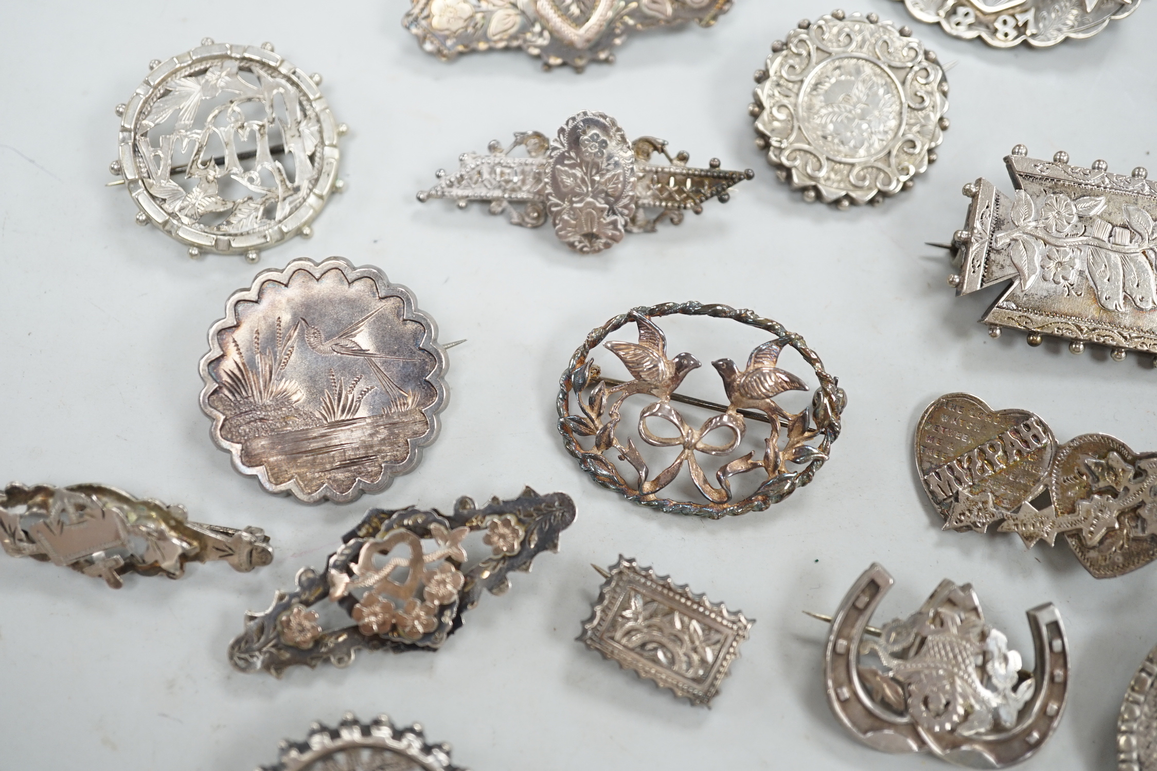 A small collection of twenty nine assorted Victorian and later silver or white metal brooches.